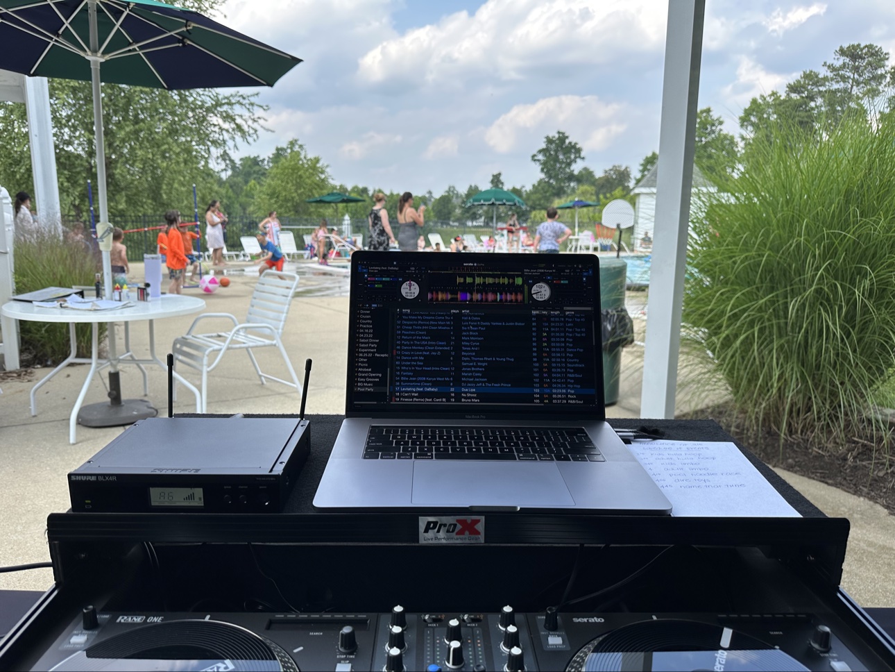 DJ setup beside a pool at an outdoor party